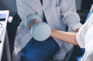 Tanımlanamayan fiziksel terapi sırasında mavi el ağırlığı kullanır