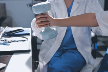 Tanımlanamayan fiziksel terapi sırasında mavi el ağırlığı kullanır