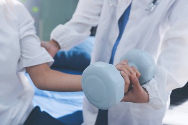 Tanımlanamayan fiziksel terapi sırasında mavi el ağırlığı kullanır