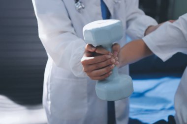 Tanımlanamayan fiziksel terapi sırasında mavi el ağırlığı kullanır