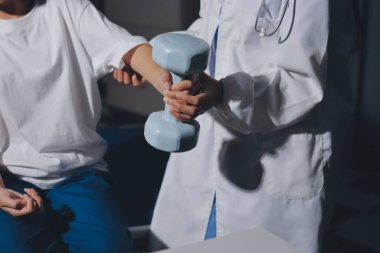 Tanımlanamayan fiziksel terapi sırasında mavi el ağırlığı kullanır