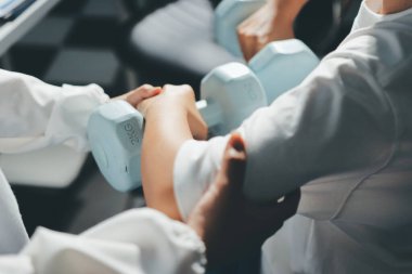 Tanımlanamayan fiziksel terapi sırasında mavi el ağırlığı kullanır