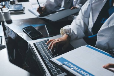 Erkek ve kadın doktorlar bir hastane odasında toplantı yapıyorlar..