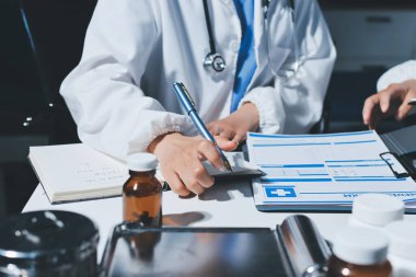 Erkek ve kadın doktorlar bir hastane odasında toplantı yapıyorlar..