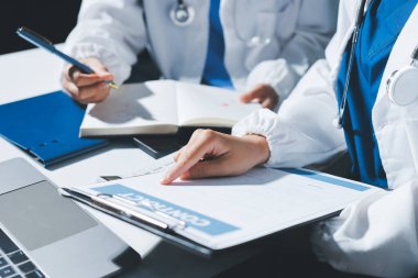 Erkek ve kadın doktorlar bir hastane odasında toplantı yapıyorlar..