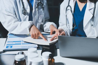 Erkek ve kadın doktorlar bir hastane odasında toplantı yapıyorlar..