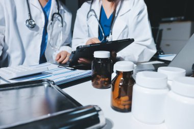 Erkek ve kadın doktorlar bir hastane odasında toplantı yapıyorlar..