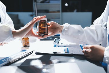 Erkek ve kadın doktorlar bir hastane odasında toplantı yapıyorlar..