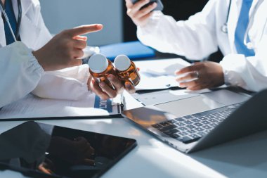 Erkek ve kadın doktorlar bir hastane odasında toplantı yapıyorlar..