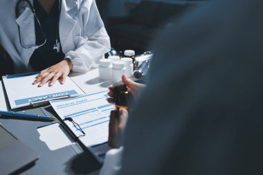 Erkek ve kadın doktorlar bir hastane odasında toplantı yapıyorlar..