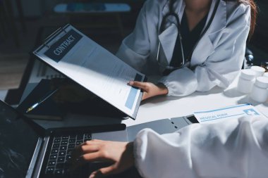 Erkek ve kadın doktorlar bir hastane odasında toplantı yapıyorlar..