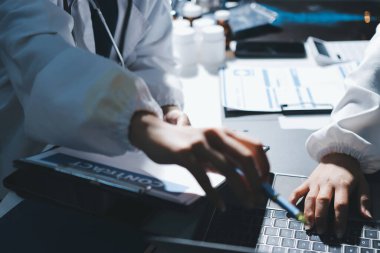 Erkek ve kadın doktorlar bir hastane odasında toplantı yapıyorlar..