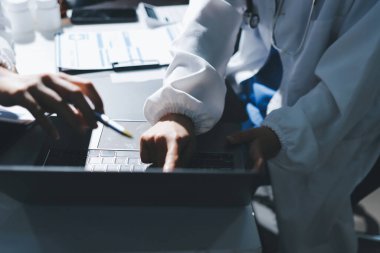 Erkek ve kadın doktorlar bir hastane odasında toplantı yapıyorlar..