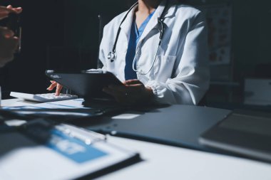 Erkek ve kadın doktorlar bir hastane odasında toplantı yapıyorlar..