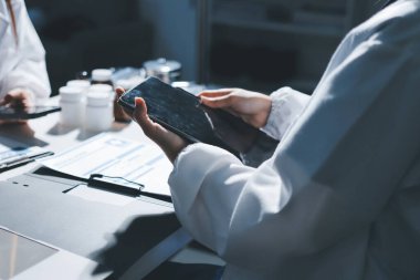 Erkek ve kadın doktorlar bir hastane odasında toplantı yapıyorlar..