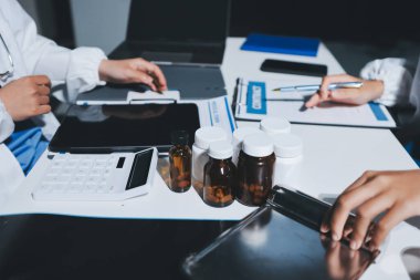 Erkek ve kadın doktorlar bir hastane odasında toplantı yapıyorlar..