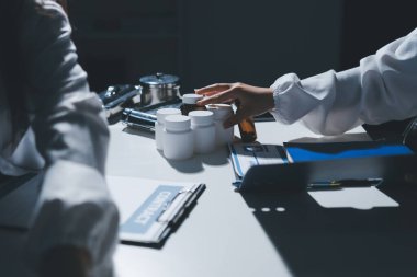 Erkek ve kadın doktorlar bir hastane odasında toplantı yapıyorlar..