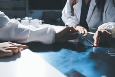 Erkek ve kadın doktorlar bir hastane odasında toplantı yapıyorlar..