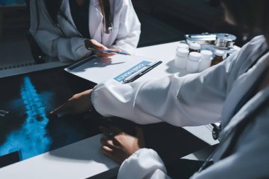 Erkek ve kadın doktorlar bir hastane odasında toplantı yapıyorlar..