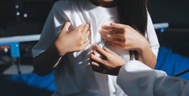 Konuşurken kalp atışı ve semptomlarını incelemek için steteskop kullanan erkek doktorun el görüntüsü.