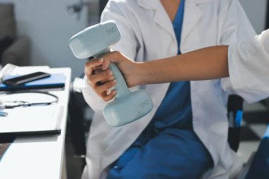 Tanımlanamayan fiziksel terapi sırasında mavi el ağırlığı kullanır