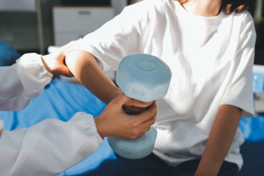 Tanımlanamayan fiziksel terapi sırasında mavi el ağırlığı kullanır