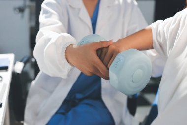 Tanımlanamayan fiziksel terapi sırasında mavi el ağırlığı kullanır