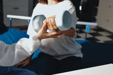 Tanımlanamayan fiziksel terapi sırasında mavi el ağırlığı kullanır