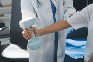 Tanımlanamayan fiziksel terapi sırasında mavi el ağırlığı kullanır