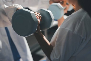 Tanımlanamayan fiziksel terapi sırasında mavi el ağırlığı kullanır