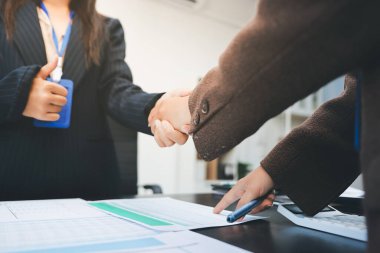 İş adamları ofiste el sıkışıyor. Kontratı imzaladıktan sonra iki iş ortağı el sıkışıyor..