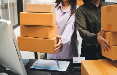 Küçük işletmeler kurma portresi KOBİ sahipleri ve iki Asyalı kadın online siparişleri kontrol ediyor. Ev işlerinde çalışan kutucuklarla çalışan ürünleri satıyorlar.