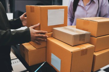 Küçük işletmeler kurma portresi KOBİ sahipleri ve iki Asyalı kadın online siparişleri kontrol ediyor. Ev işlerinde çalışan kutucuklarla çalışan ürünleri satıyorlar.