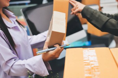 Küçük işletmeler kurma portresi KOBİ sahipleri ve iki Asyalı kadın online siparişleri kontrol ediyor. Ev işlerinde çalışan kutucuklarla çalışan ürünleri satıyorlar.