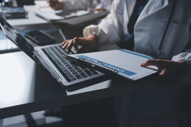 Erkek ve kadın doktorlar bir hastane odasında toplantı yapıyorlar..