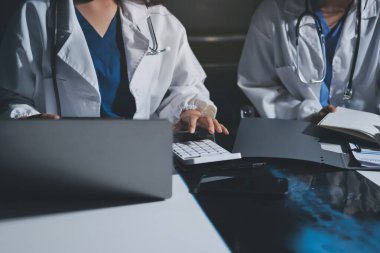 Erkek ve kadın doktorlar bir hastane odasında toplantı yapıyorlar..