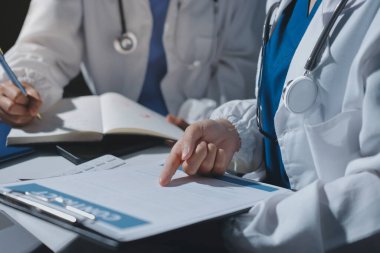 Erkek ve kadın doktorlar bir hastane odasında toplantı yapıyorlar..