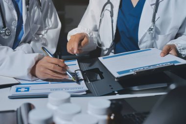 Erkek ve kadın doktorlar bir hastane odasında toplantı yapıyorlar..