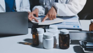 Erkek ve kadın doktorlar bir hastane odasında toplantı yapıyorlar..