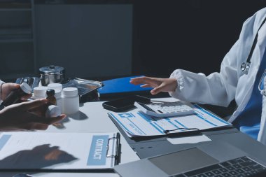 Erkek ve kadın doktorlar bir hastane odasında toplantı yapıyorlar..