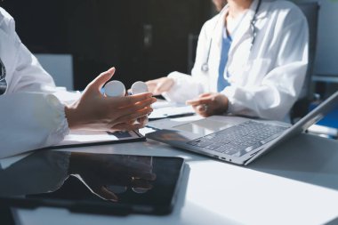 Erkek ve kadın doktorlar bir hastane odasında toplantı yapıyorlar..