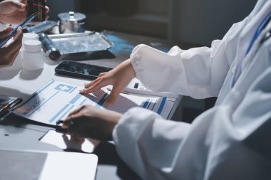 Erkek ve kadın doktorlar bir hastane odasında toplantı yapıyorlar..