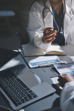 Erkek ve kadın doktorlar bir hastane odasında toplantı yapıyorlar..