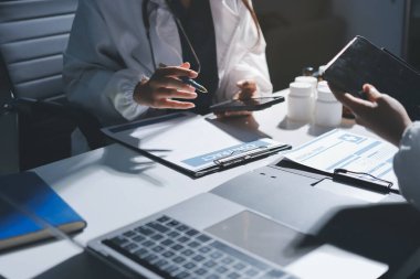 Erkek ve kadın doktorlar bir hastane odasında toplantı yapıyorlar..