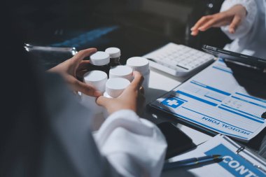 Erkek ve kadın doktorlar bir hastane odasında toplantı yapıyorlar..