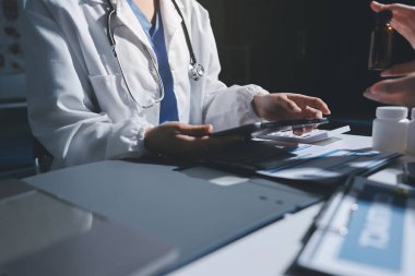 Erkek ve kadın doktorlar bir hastane odasında toplantı yapıyorlar..