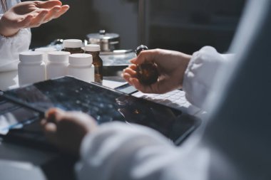 Erkek ve kadın doktorlar bir hastane odasında toplantı yapıyorlar..