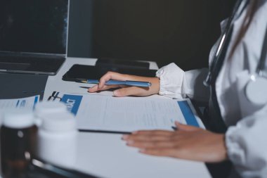 Erkek ve kadın doktorlar bir hastane odasında toplantı yapıyorlar..