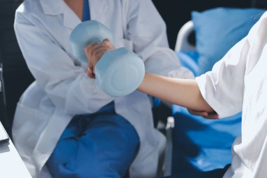 Tanımlanamayan fiziksel terapi sırasında mavi el ağırlığı kullanır