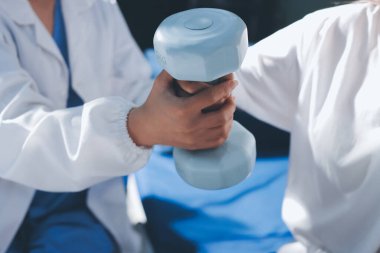 Tanımlanamayan fiziksel terapi sırasında mavi el ağırlığı kullanır